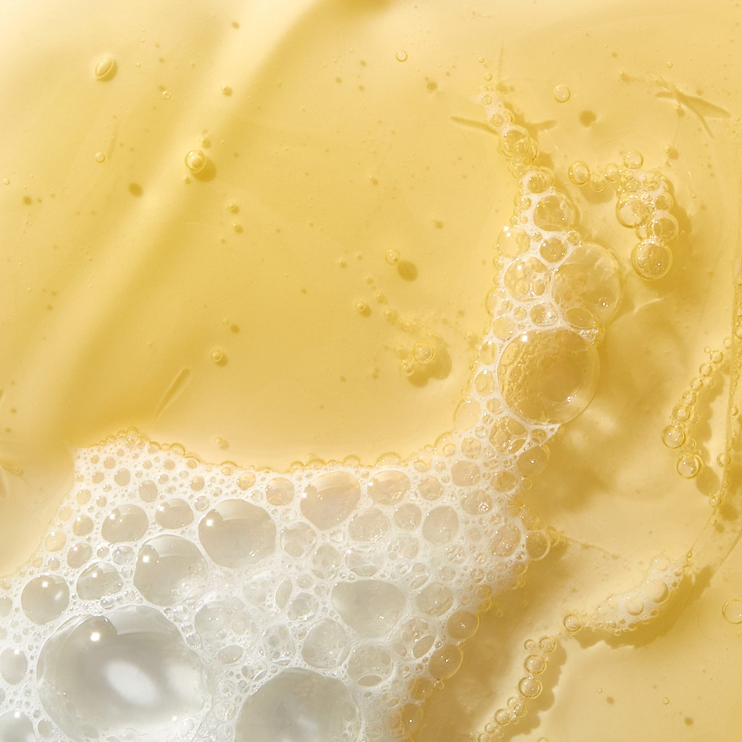 Gros plan d'un liquide jaunâtre avec des bulles de mousse.