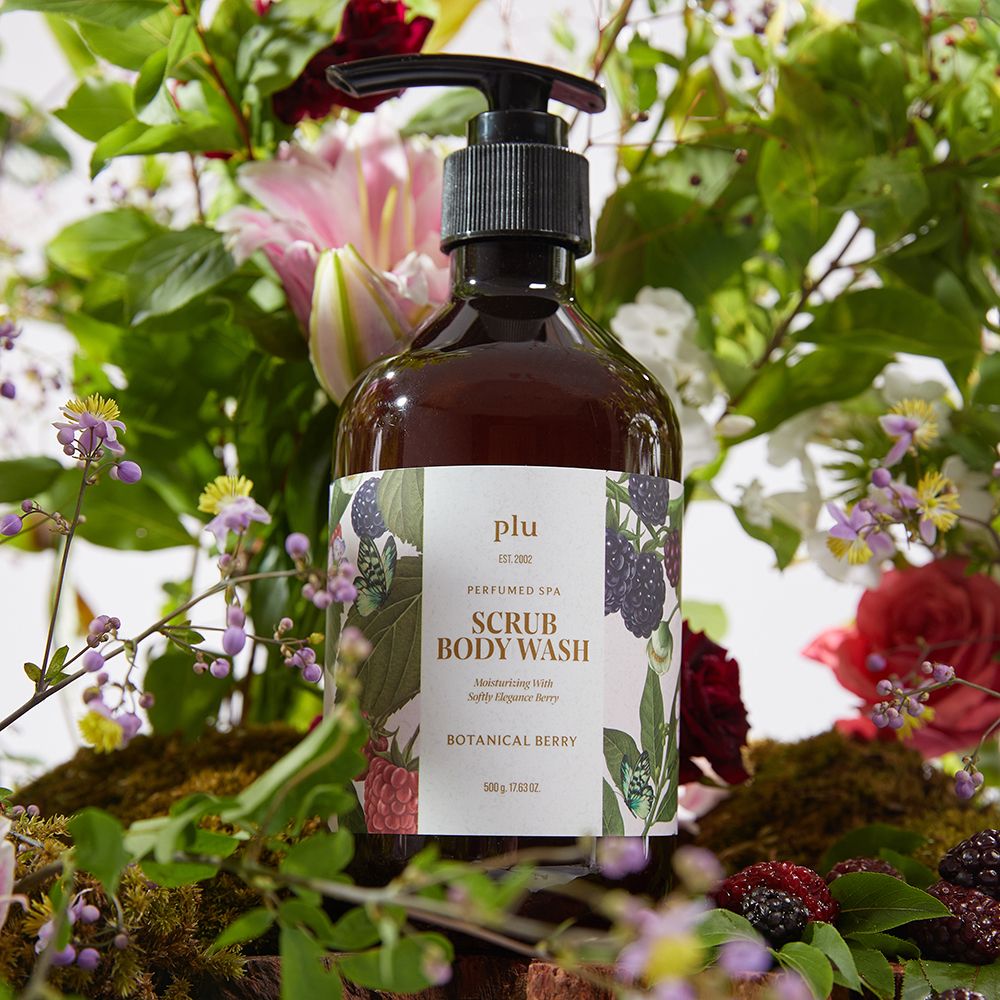 Flacon brun avec pompe noire. Étiquette avec nom du produit et illustrations florales. Entouré de fleurs et de baies.