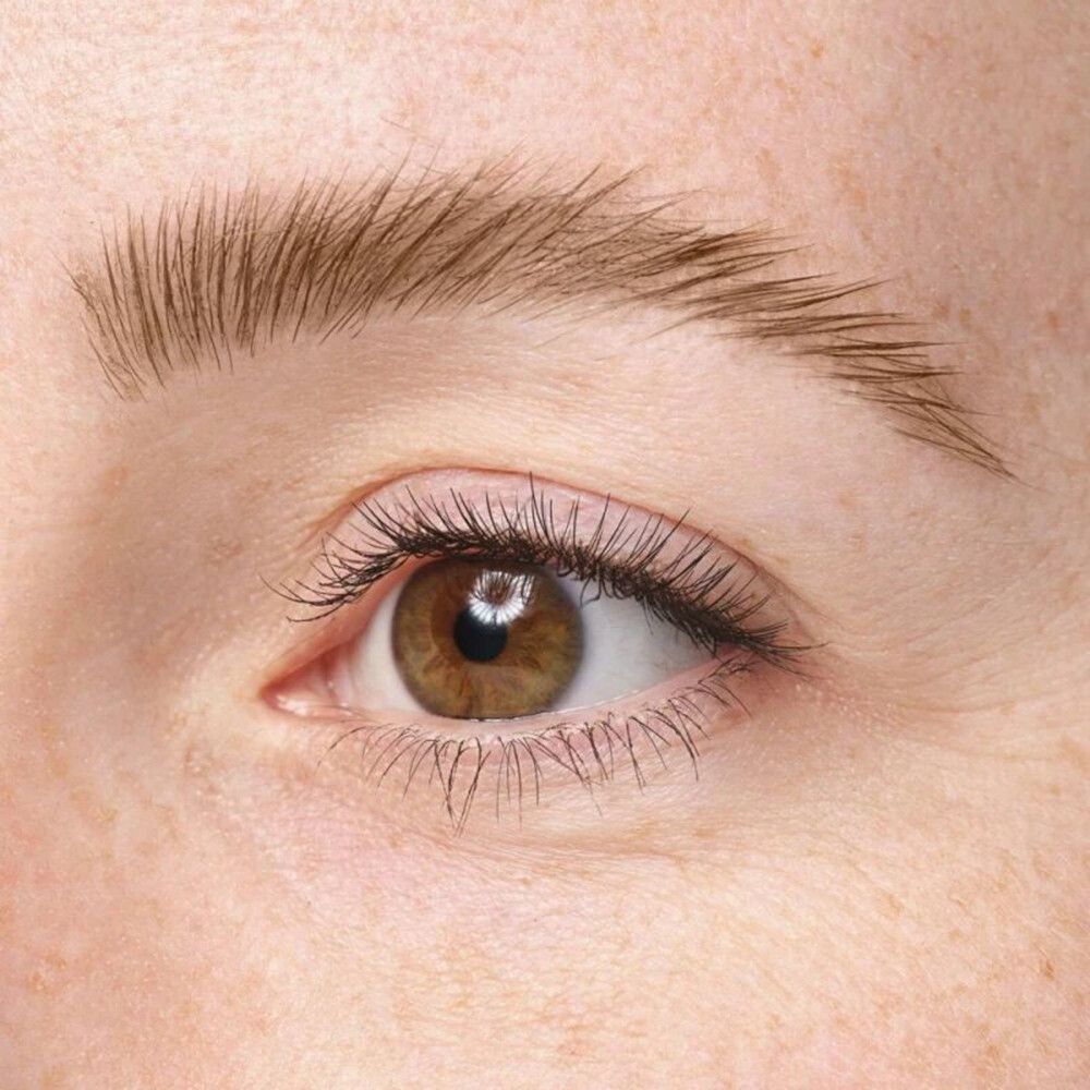 Gros plan sur un œil avec sourcil. Yeux bruns, peau claire. Sourcils dessinés.