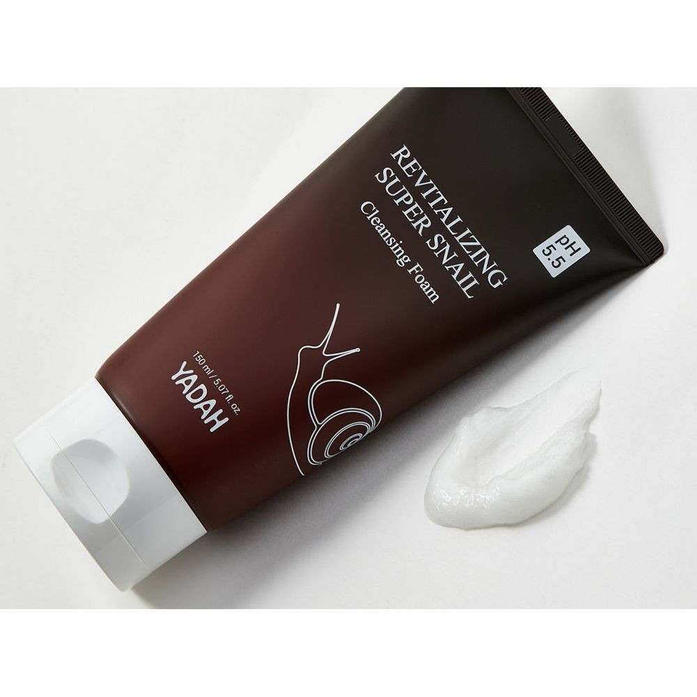 Bruine tube met witte dop. Opschrift: Revitalizing Super Snail Cleansing Foam. Logo: slak. pH 5.5. Merk: YADAH. Schuim ernaast.