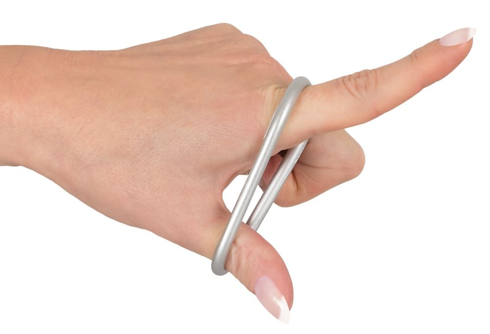 Main avec deux anneaux de pénis argentés métalliques en silicone flexible sur les doigts.