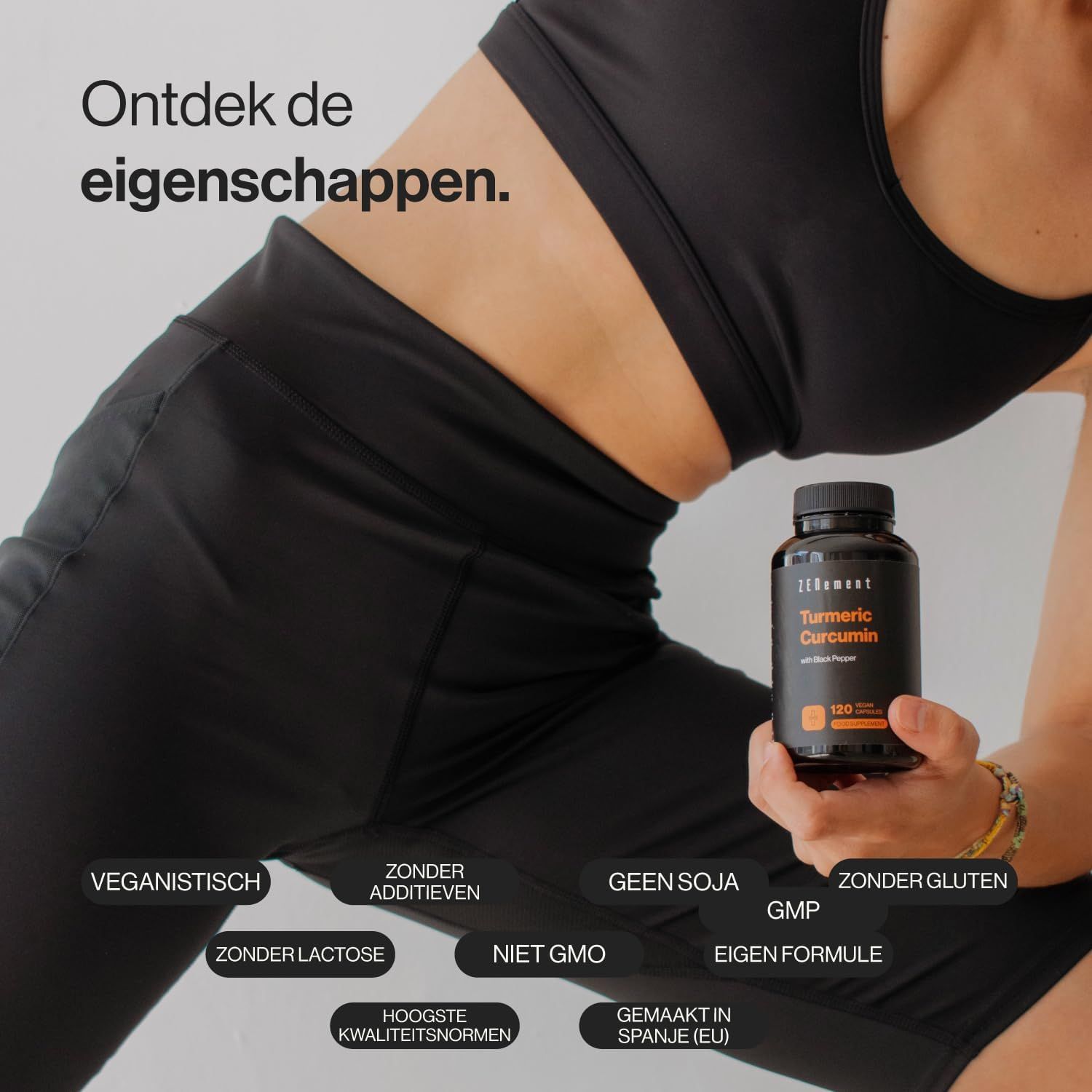 Een persoon houdt een fles Zenement kurkuma-capsules vast. "VEGAN", "SENZA ADDITIVI", "GMP" zijn zichtbaar.
