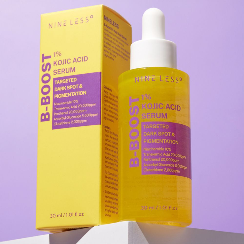 Gele fles en doos. Opschrift: NINE LESS, B-Boost, 1% Kojic Acid Serum. 30 ml. Paarse achtergrond.