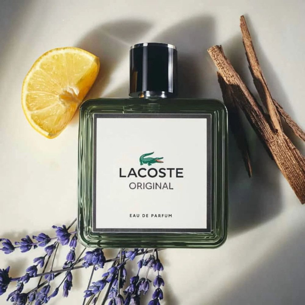 Flacon Lacoste Original EdP Nat. Spray avec citron, lavande et bois. Forme carrée, cadre vert, étiquette blanche.