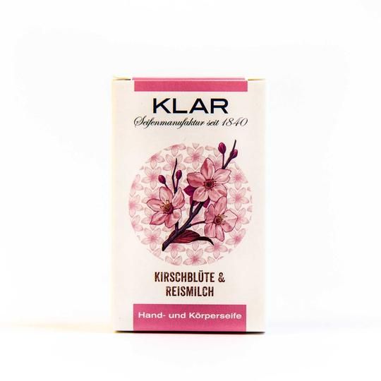 Klar zeepverpakking. Wit met roze accenten. Illustratie van kersenbloesem. Opschrift: Kirschblüte & Reismilch, hand- en lichaamszeep.