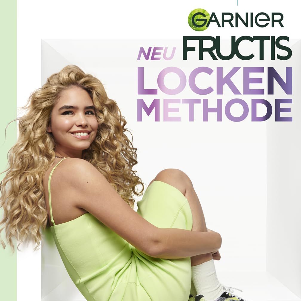 Jeune femme aux cheveux bouclés. Texte: Garnier Fructis, Locken Methode.