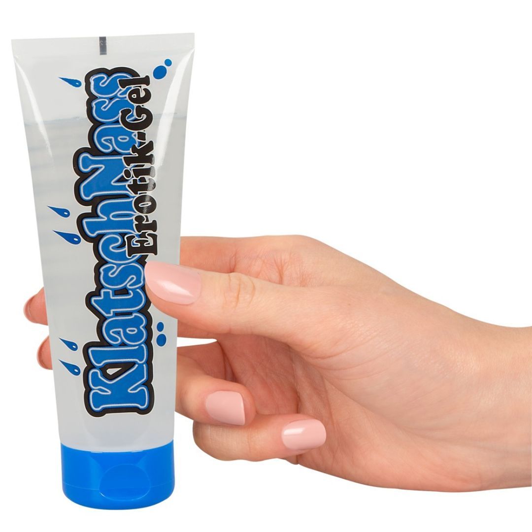 Tube de gel KlatschNass Erotik, bleu et blanc. Tenu en main. Graphique de gouttes bleues.