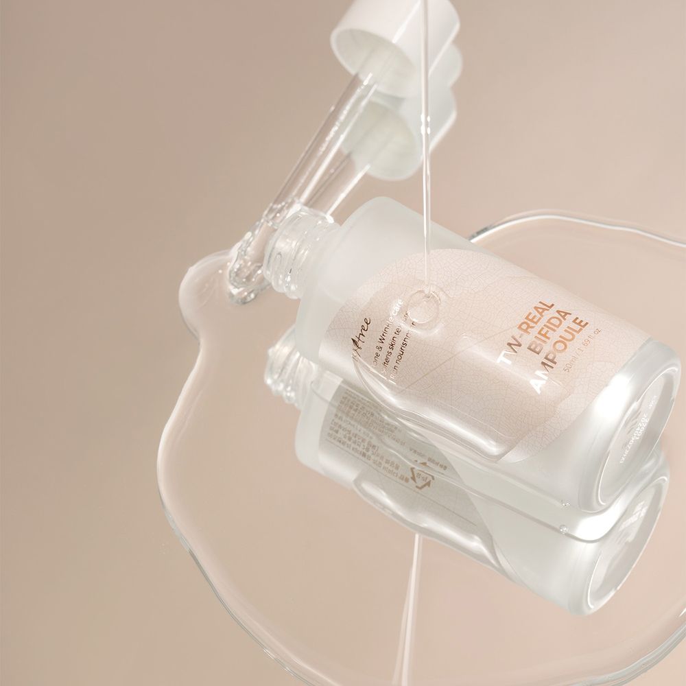 Sérum versé d'une bouteille sur une surface. Inscription : TW-REAL BIFIDA AMPOULE.
