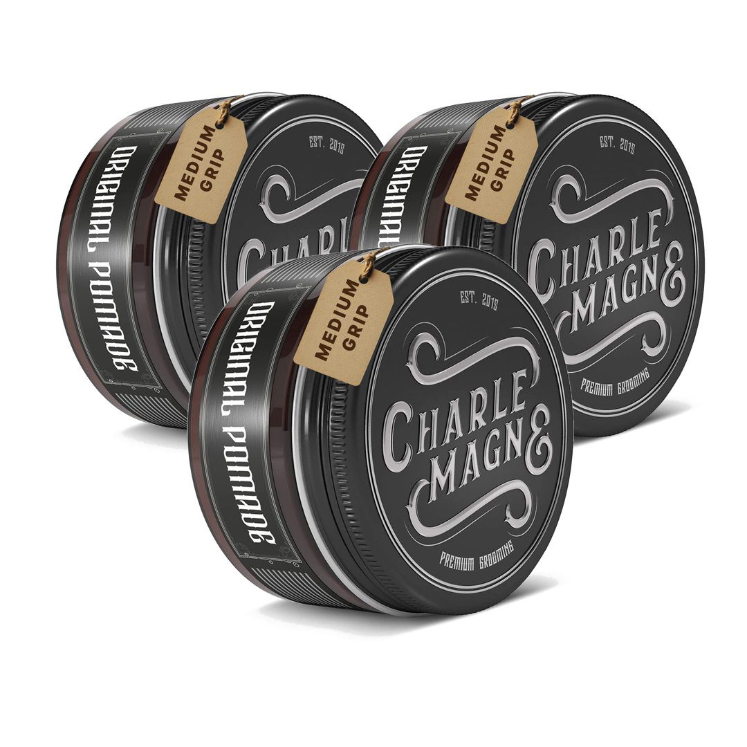 Drie ronde blikken met zwarte deksels, etiketten met "CHARLE MAGN&" en "ORIGINAL POMADE".