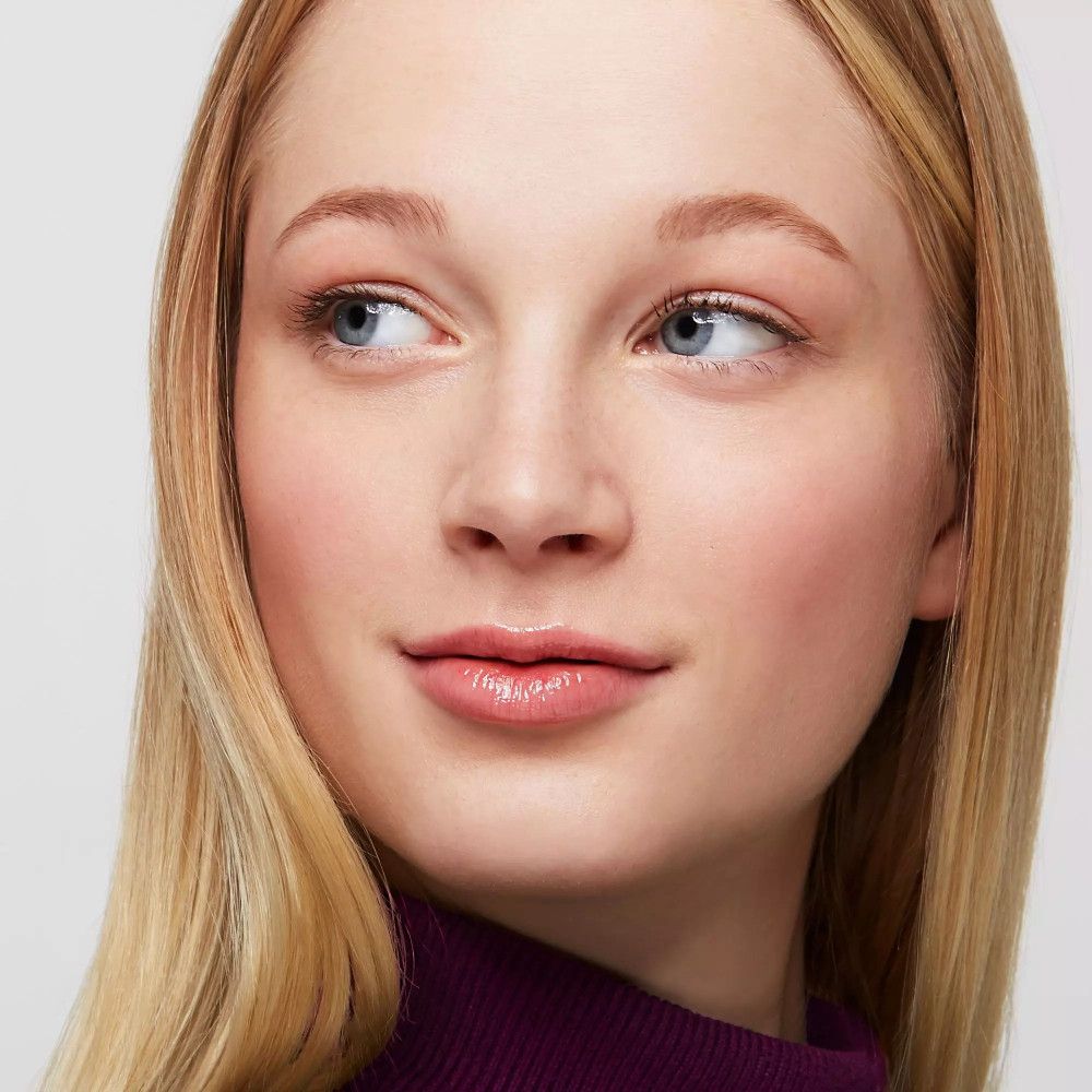 Portret van een vrouw met blond haar en subtiel opgemaakte wenkbrauwen. Ze kijkt opzij.