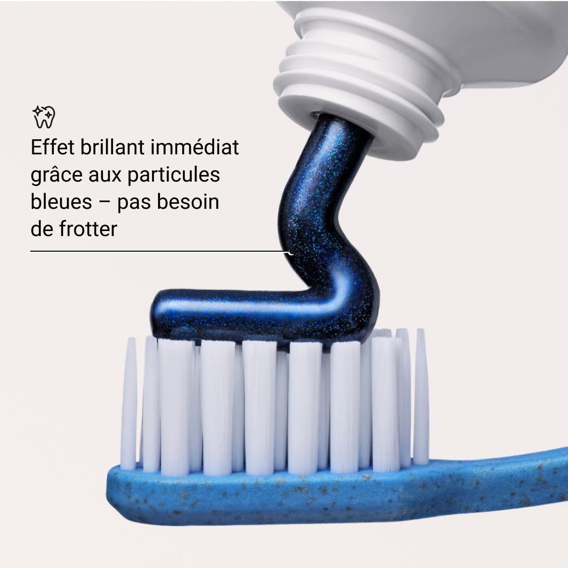 Dentifrice bleu appliqué sur une brosse à dents. Texte: Effet brillant immédiat grâce aux particules bleues - pas besoin de frotter.