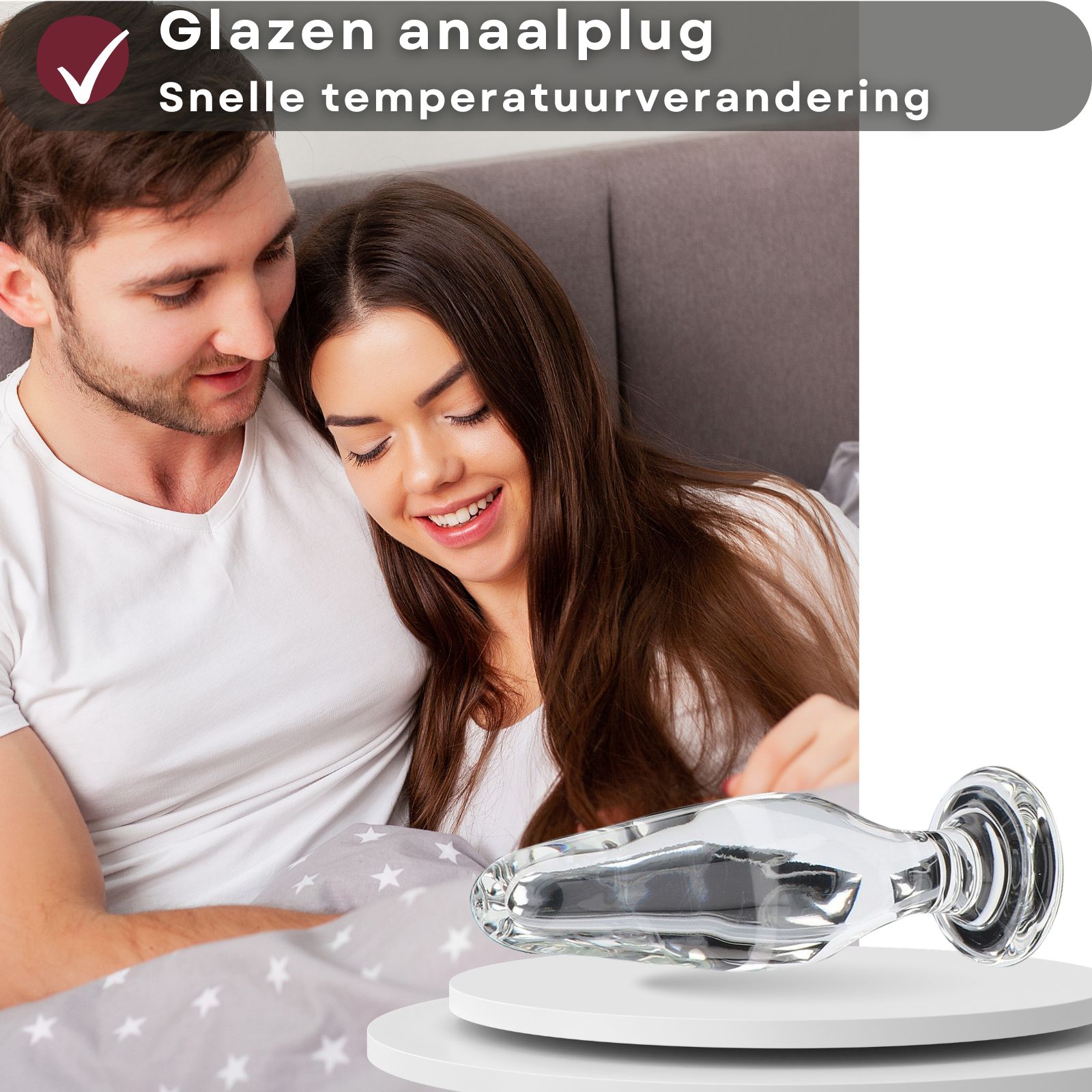 Glazen anale plug. Conische vorm, transparant oppervlak. Koppel op de achtergrond.