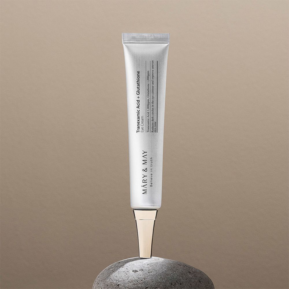 Zilveren tube met tekst. Geplaatst op steen. Gouden applicator. MARY & MAY logo.