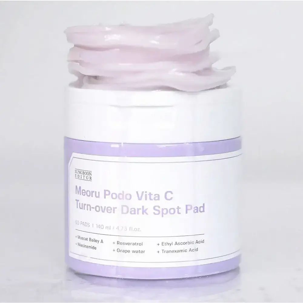 Product met pads. Opschrift: Meoru Podo Vita C Turn-over Dark Spot Pad. Pads op de pot.