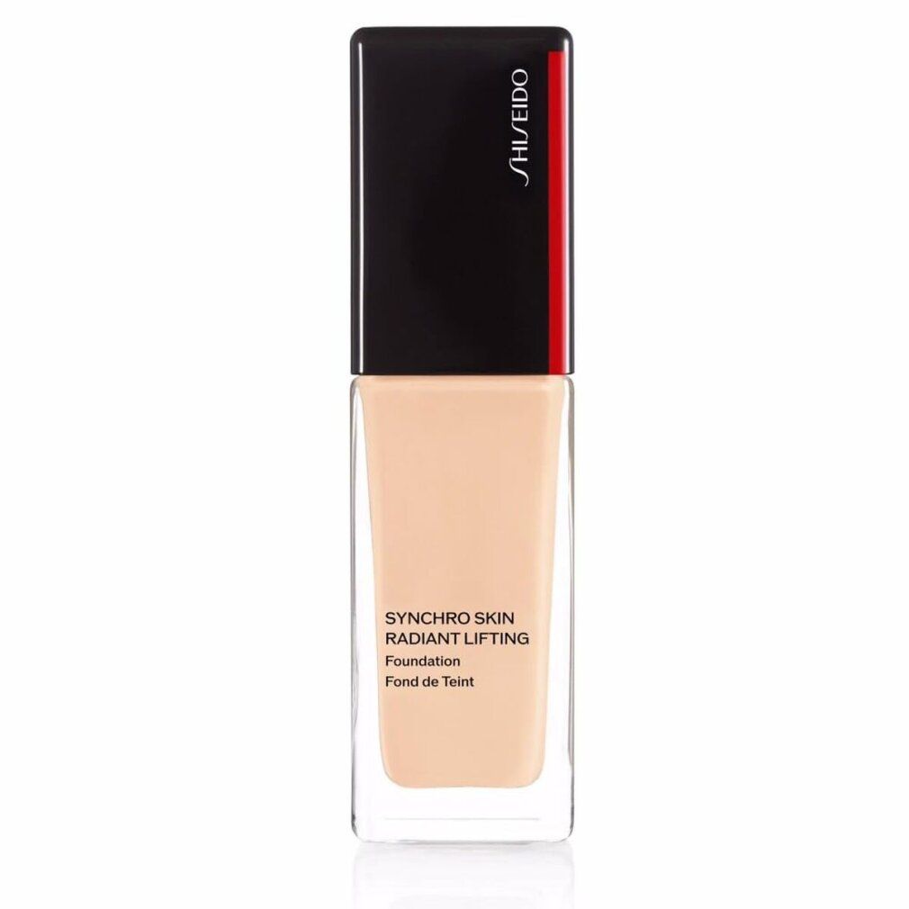 Flacon de fond de teint. Bouchon noir avec bande rouge. Inscription: Synchro Skin Radiant Lifting Foundation. Teinte.