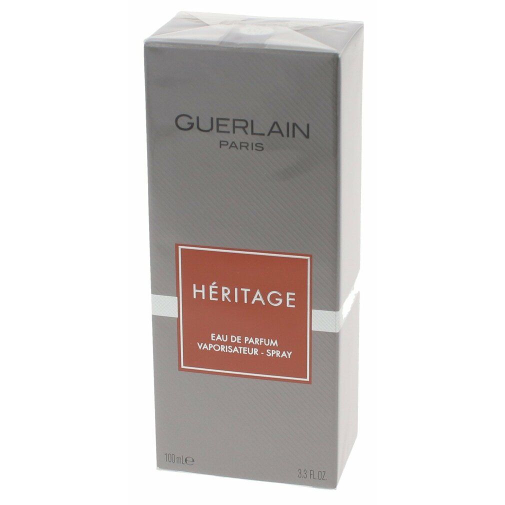 Grijze rechthoekige verpakking met oranje label. Guerlain Paris, Héritage, Eau de Parfum Vaporisateur-Spray.