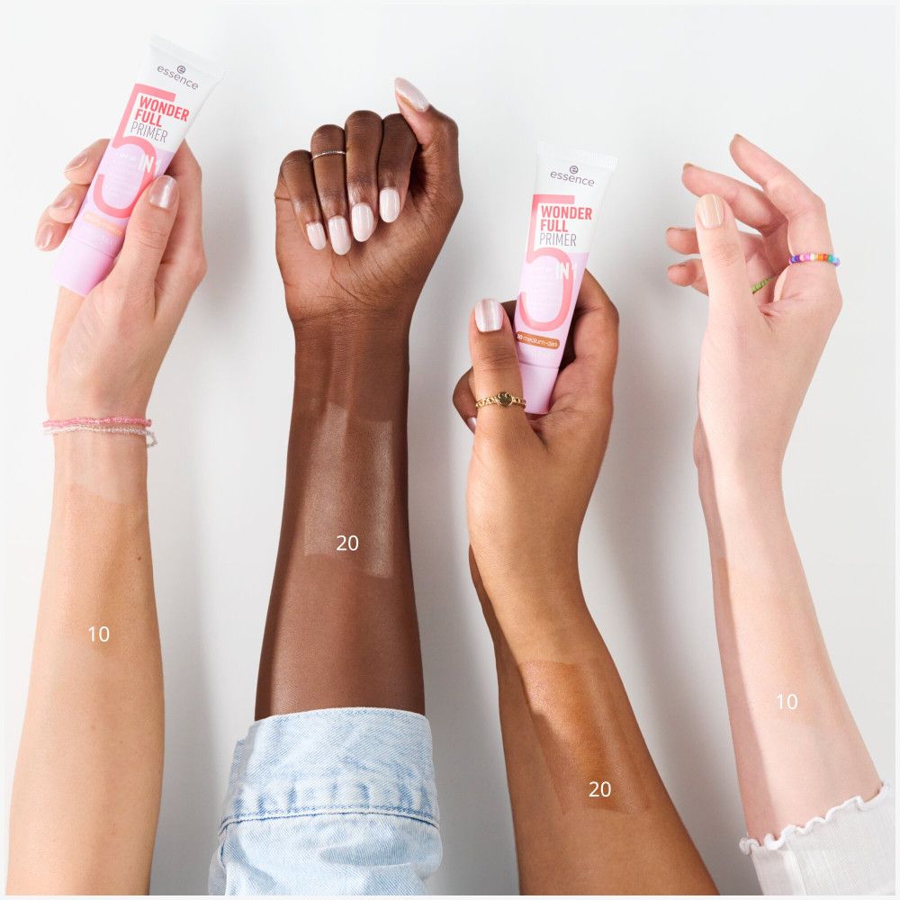 Quatre bras de teints différents tiennent Essence Wonder Full 5-en-1 Primer. Numéros sur les bras.