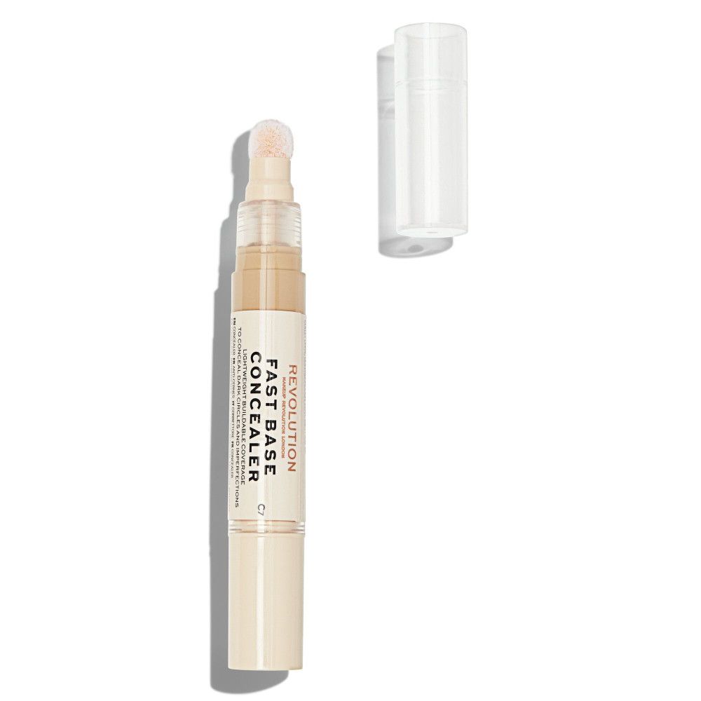 Concealer en bâton avec applicateur éponge et bouchon. Nom du produit et marque visibles. Couleur beige.