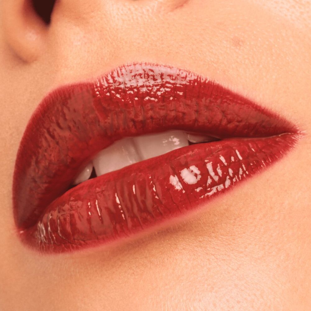 Close-up van lippen met dieprode Lip Tint. Glanzende finish.