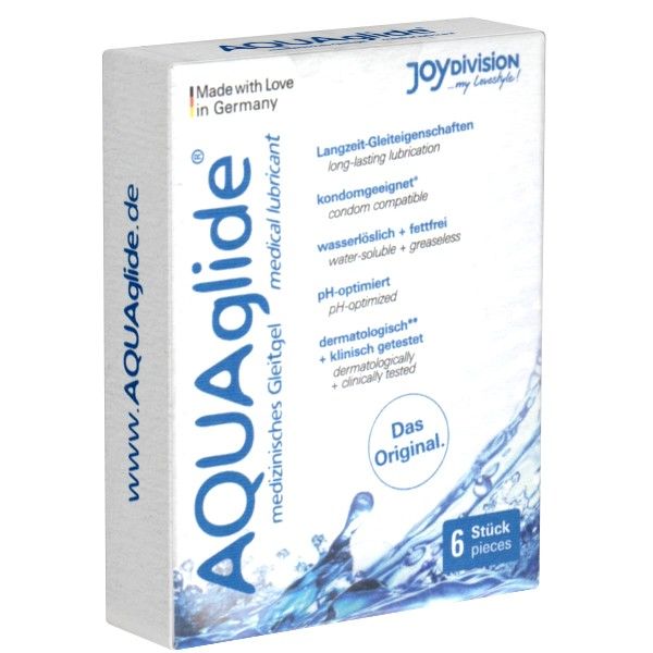 Boîte blanche avec texte "AQUAglide". Contient 6 sachets individuels. Inscriptions : "lubrifiant médical", "compatible préservatif", "pH optimisé".