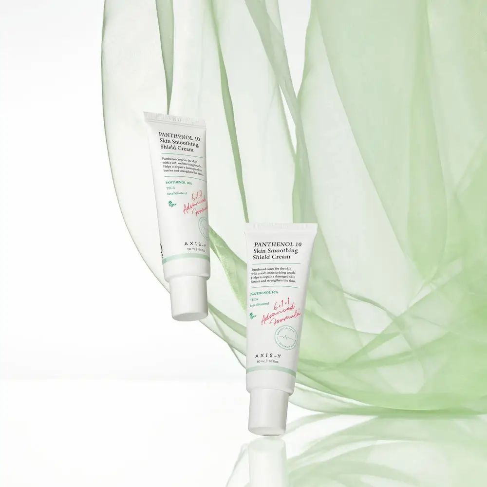 Twee tubes 'Panthenol 10 Skin Smoothing Shield Cream' op groene achtergrond.