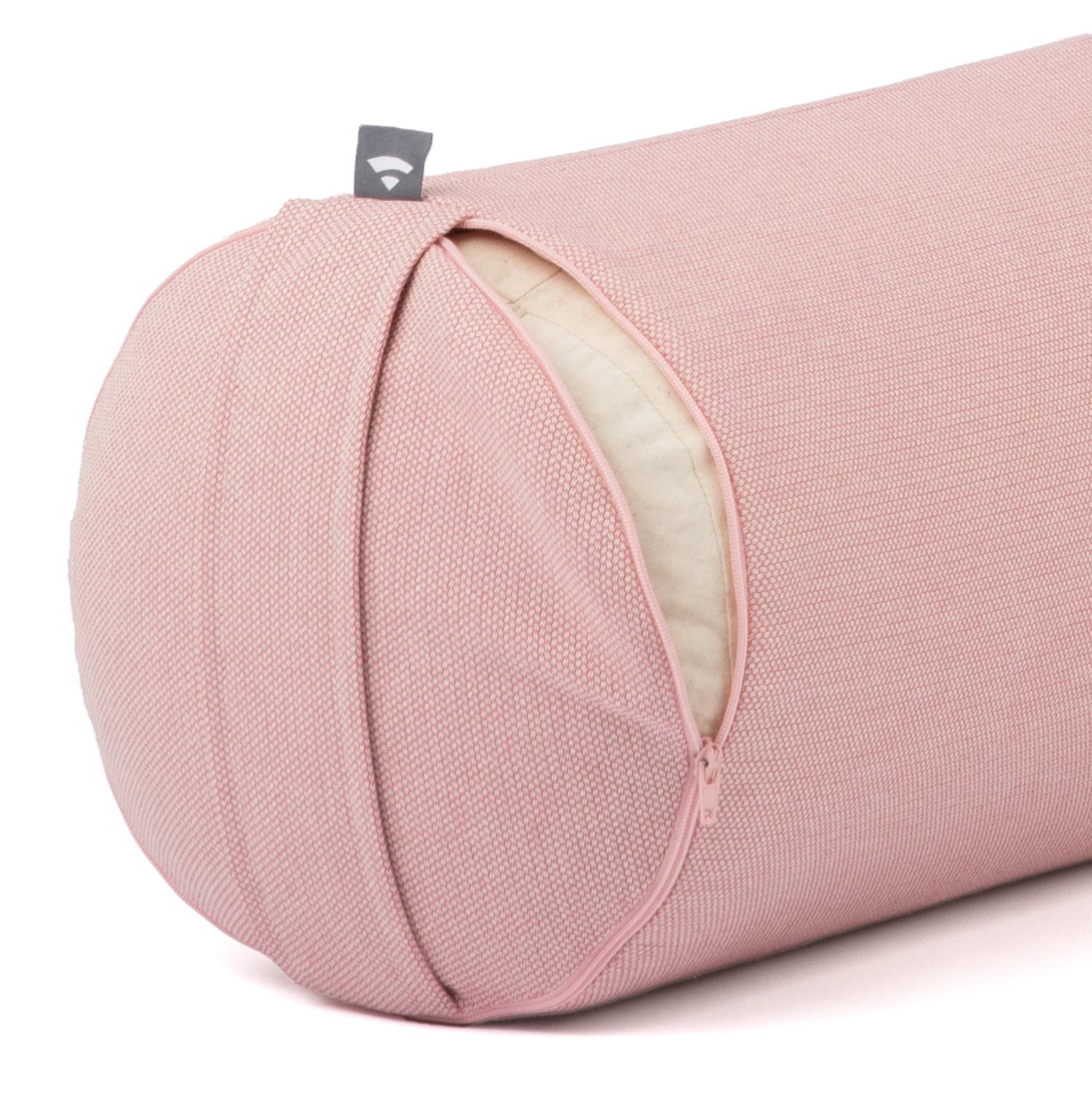 Close-up van een yogabolster. Roze stof met rits. Klein label aan het uiteinde.