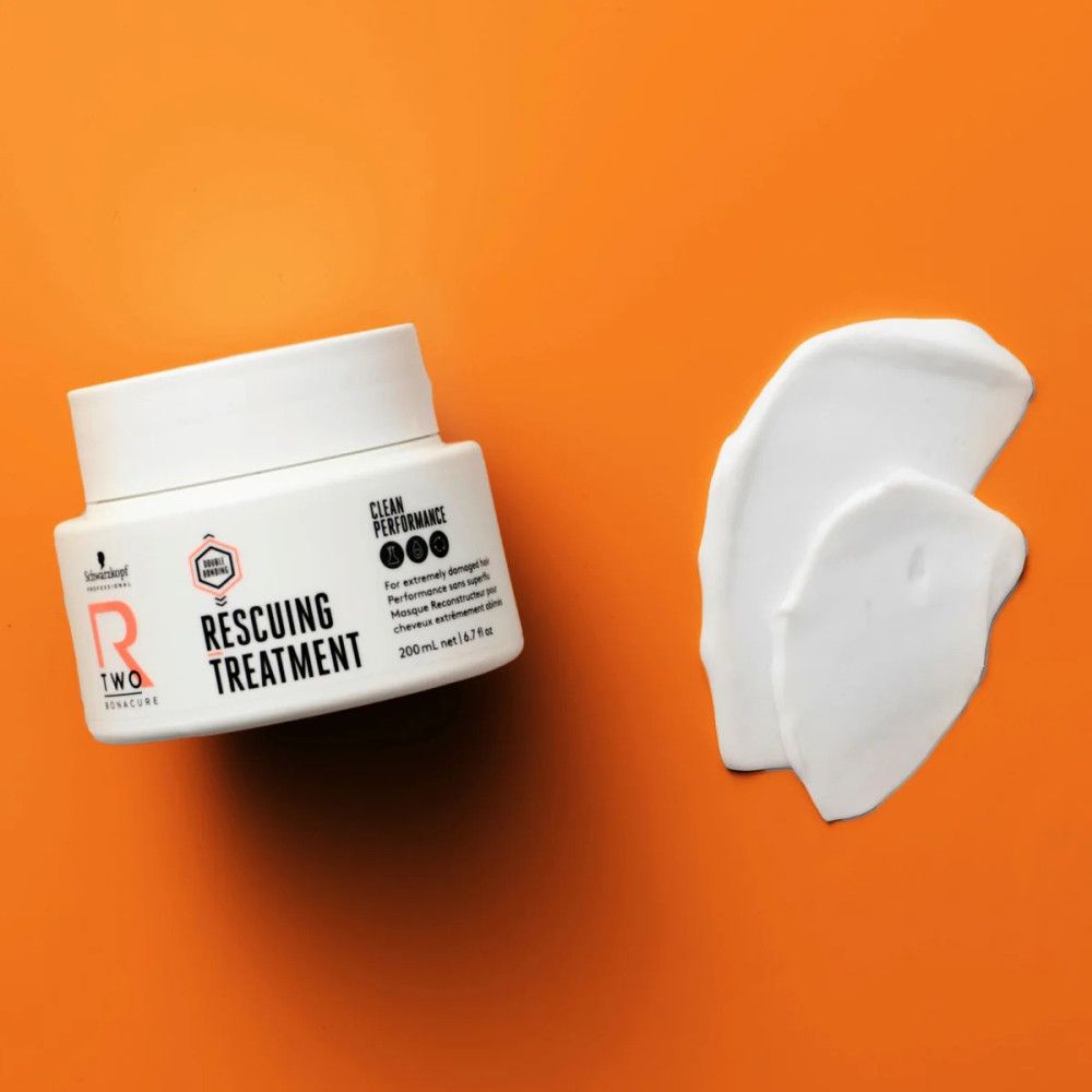 Pot blanc et échantillon de produit sur fond orange. Texte: R-TWO Rescuing Treatment, 200 ml. Logo Schwarzkopf.