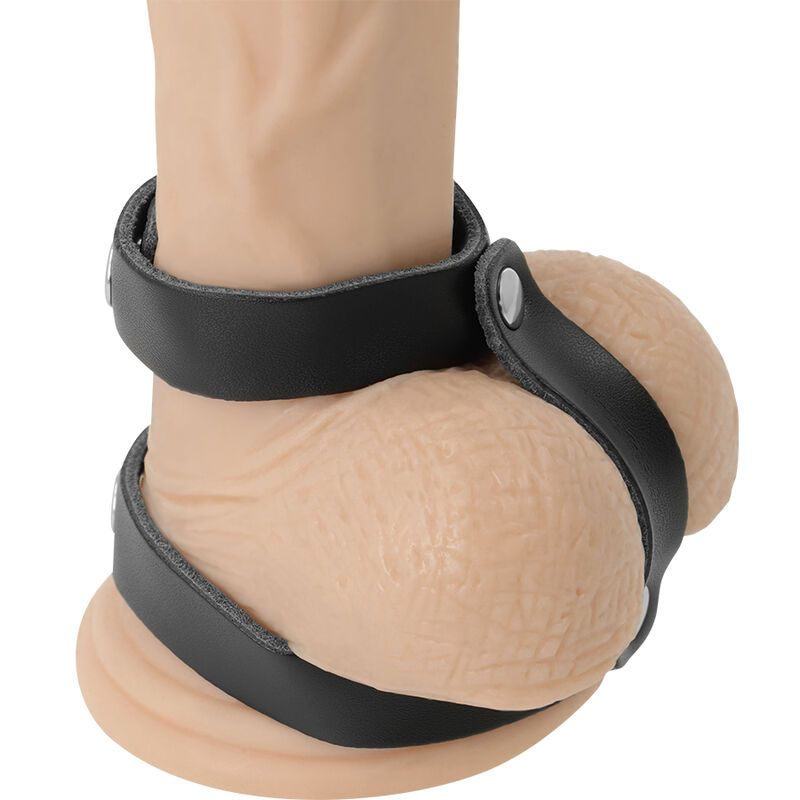 Harnais de pénis en cuir noir placé autour d'un pénis et d'un scrotum sur un mannequin.