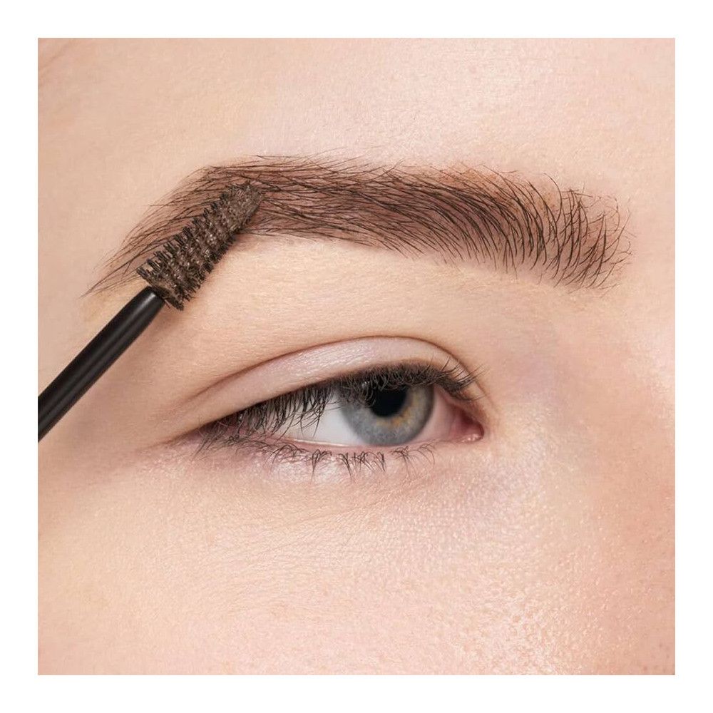 Œil avec sourcil brossé. Brosse et sourcil bruns.