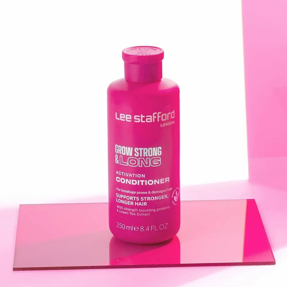 Roze fles met tekst. Tekst: Grow Strong & Long Conditioner. 250 ml. Merk: Lee Stafford. Op glazen plaat.