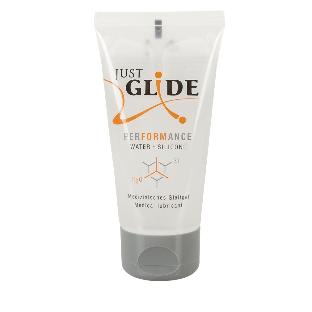 Tube transparent avec bouchon gris. Inscription: JUST GLIDE PERFORMANCE WATER + SILICONE. Texte: Lubrifiant médical.