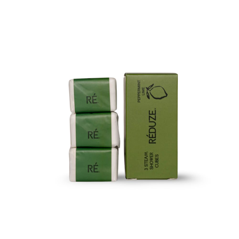 3 in papier verpakte doucheblokjes naast een groene doos. Opschrift: RÉDUZE.