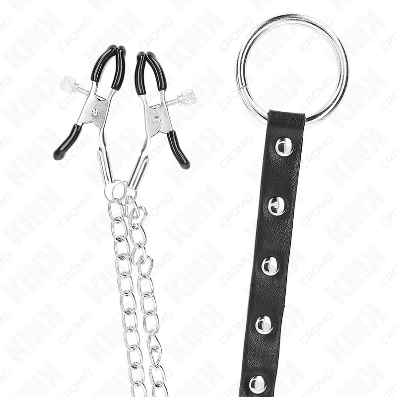 Twee verstelbare metalen tepelklemmen met zwarte rubberen uiteinden, verbonden door een zilveren ketting. Een zwarte leren band met klinknagels en een metalen ring is bevestigd.