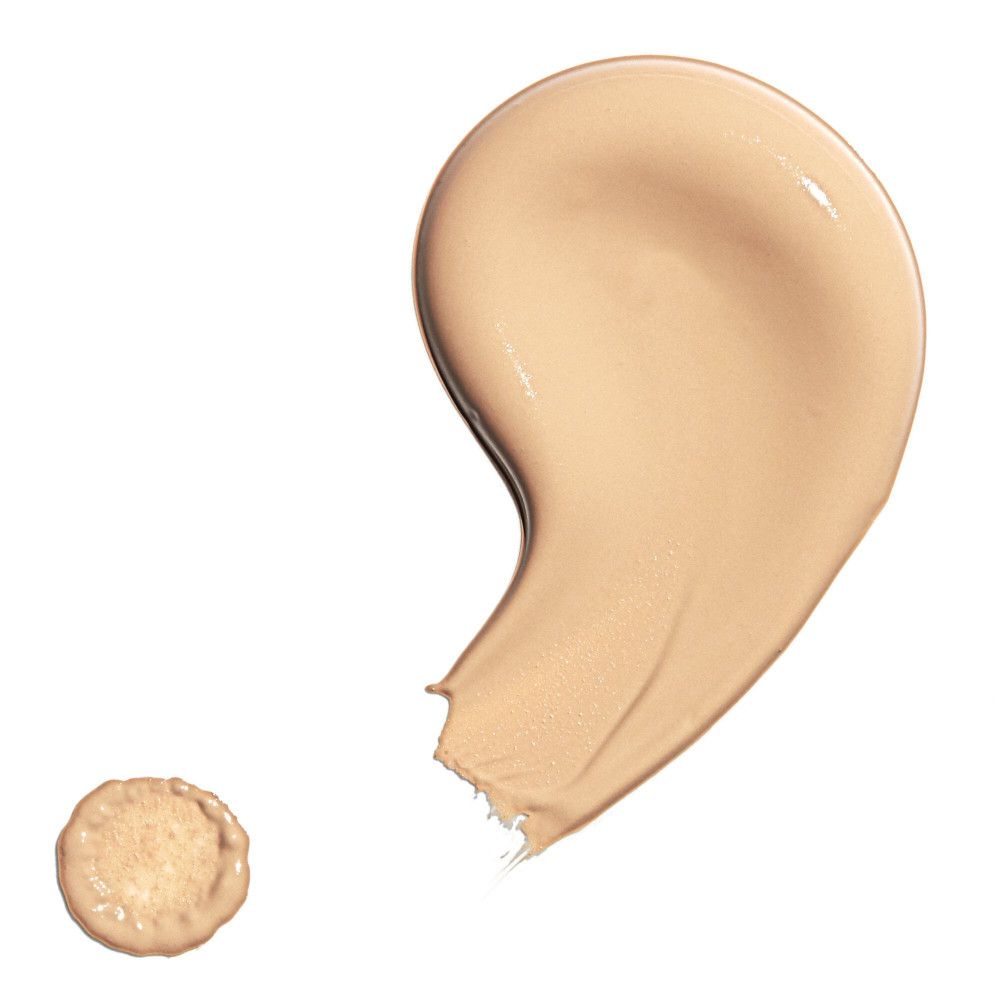 Deux échantillons de correcteur. Une grande tache incurvée et une petite tache ronde. Couleur beige.