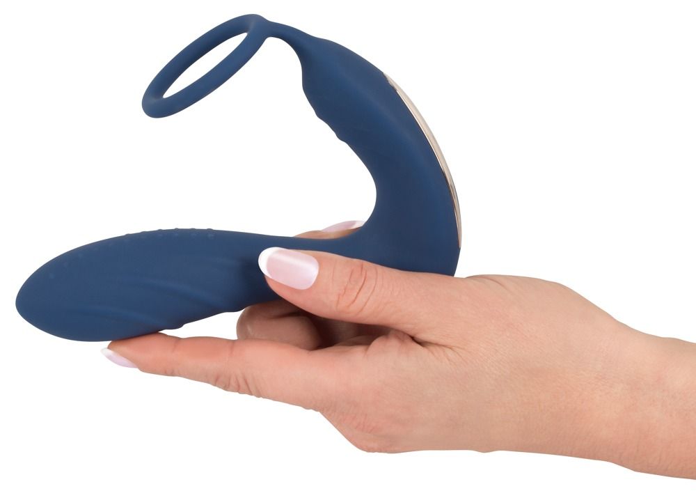 Plug anal bleu avec anneau pénien et stimulateur périnéal, tenu dans une main. Forme incurvée.
