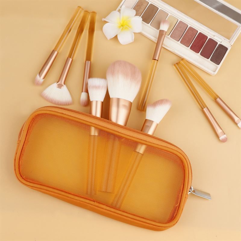 Ensemble de pinceaux de maquillage avec manches orange transparents, poils roses, dans une trousse orange. Avec palette.