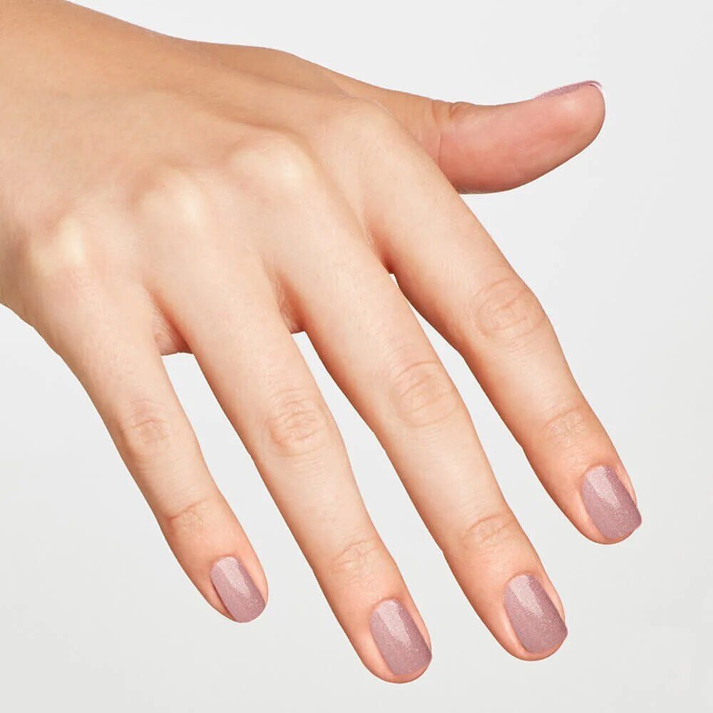 Main avec ongles vernis. Vernis à ongles rose sur les ongles.