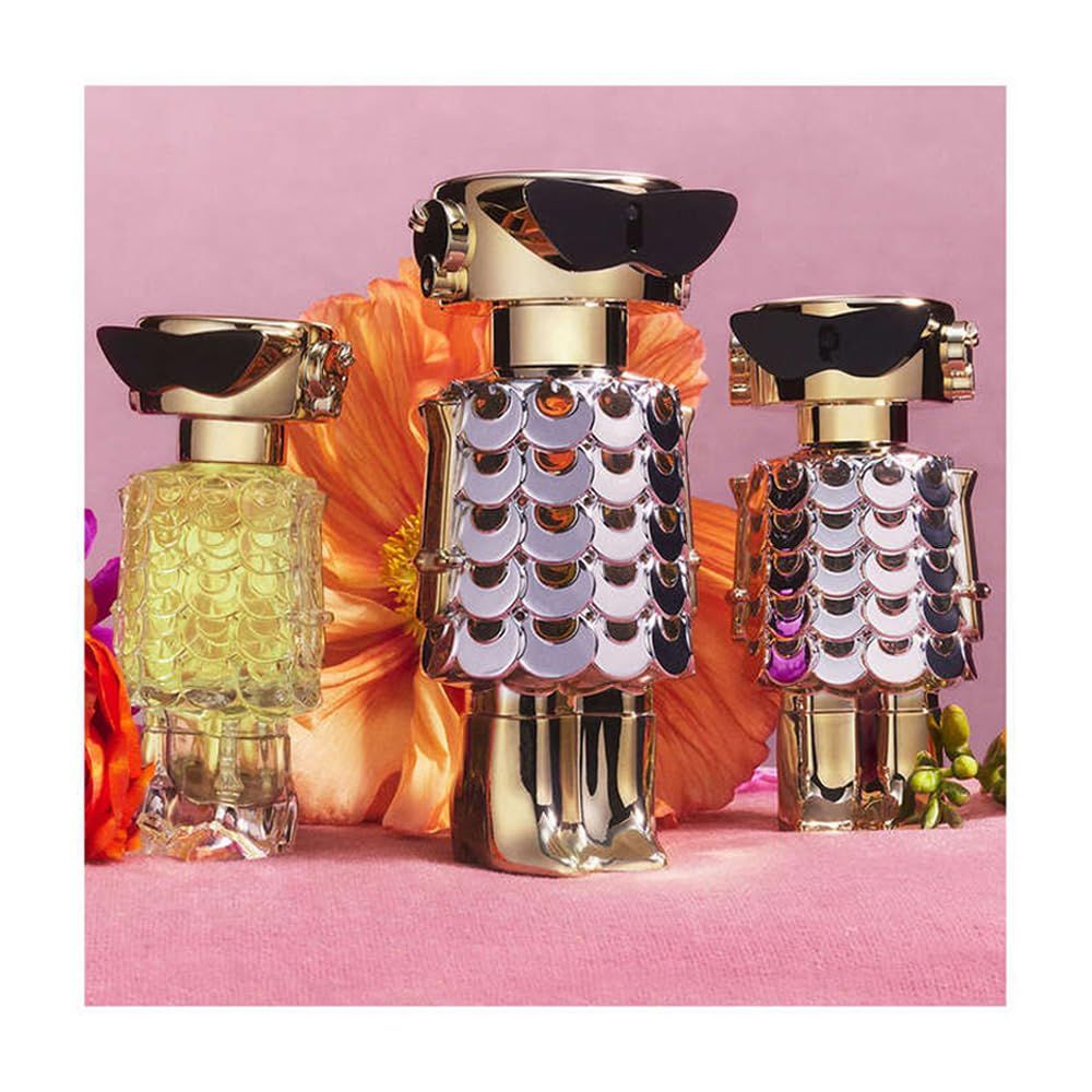 Drie flacons in robotvorm. Goud, zilver, zwart. Op roze achtergrond met bloemen. Verschillende kleuren.