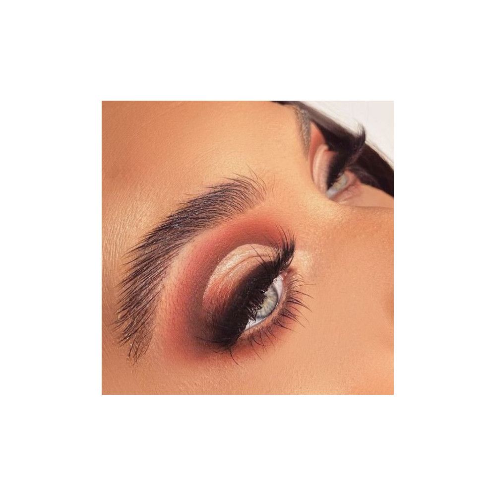 Gros plan d'un œil maquillé avec de faux cils. Fards à paupières bruns, yeux bleus.