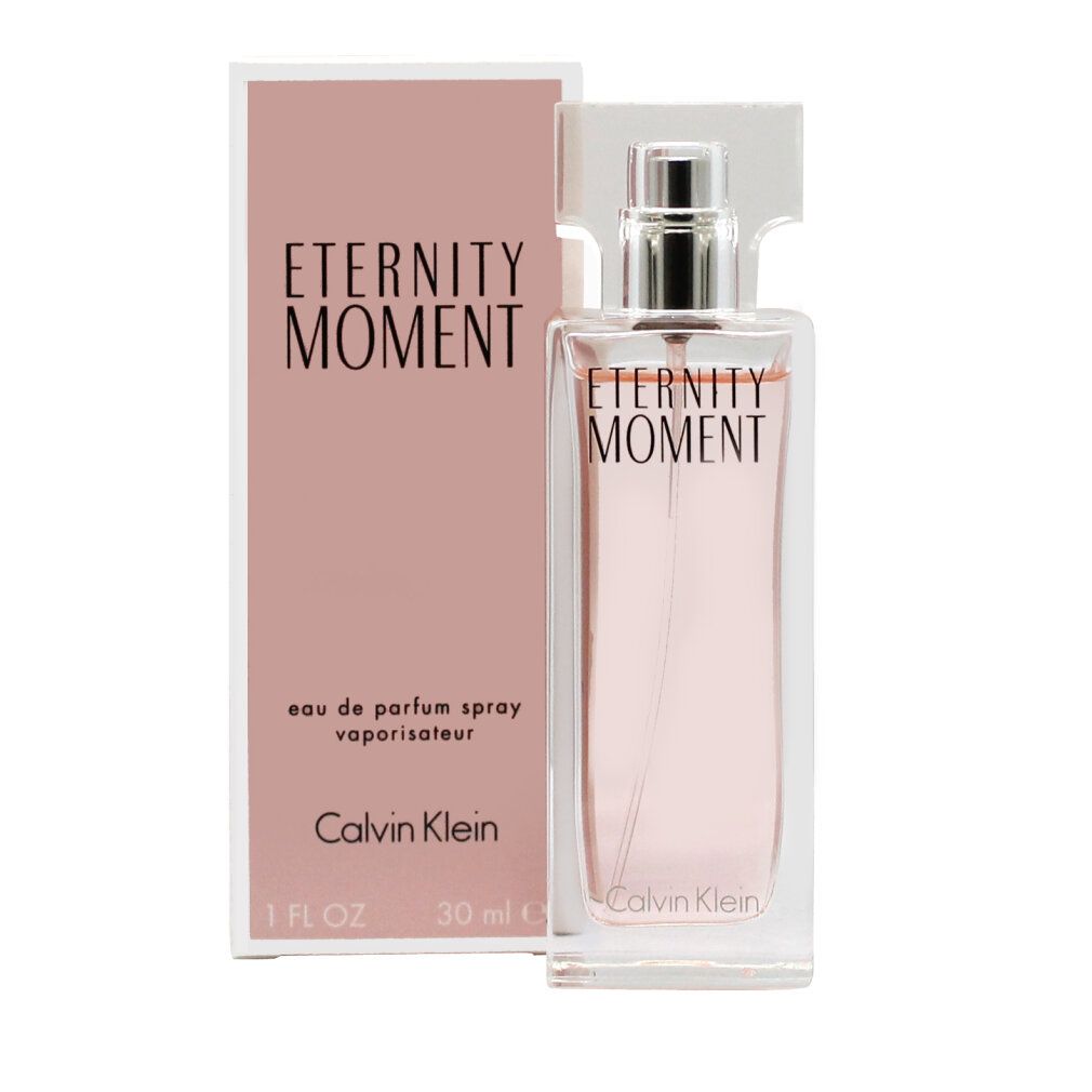 Flacon de parfum et emballage. Inscription "Eternity Moment" et "Calvin Klein". Liquide rose dans un flacon en verre rectangulaire.