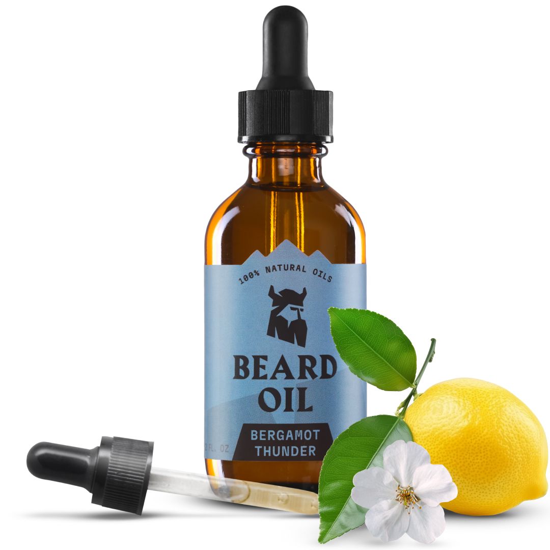 Flacon en verre ambré avec pipette, étiquette "Beard Oil" et motif bergamote, à côté d'un citron et d'une fleur.