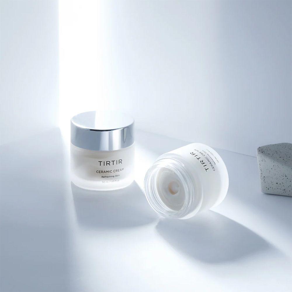 Twee potten Tir Tir Ceramic Cream op een lichte ondergrond met lichteffecten.