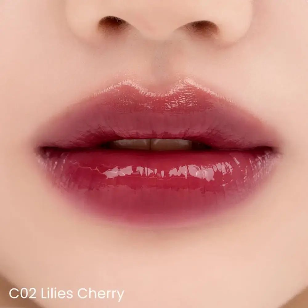 Close-up van lippen met glanzende, kerskleurige lipgloss. Tekst: C02 Lilies Cherry.