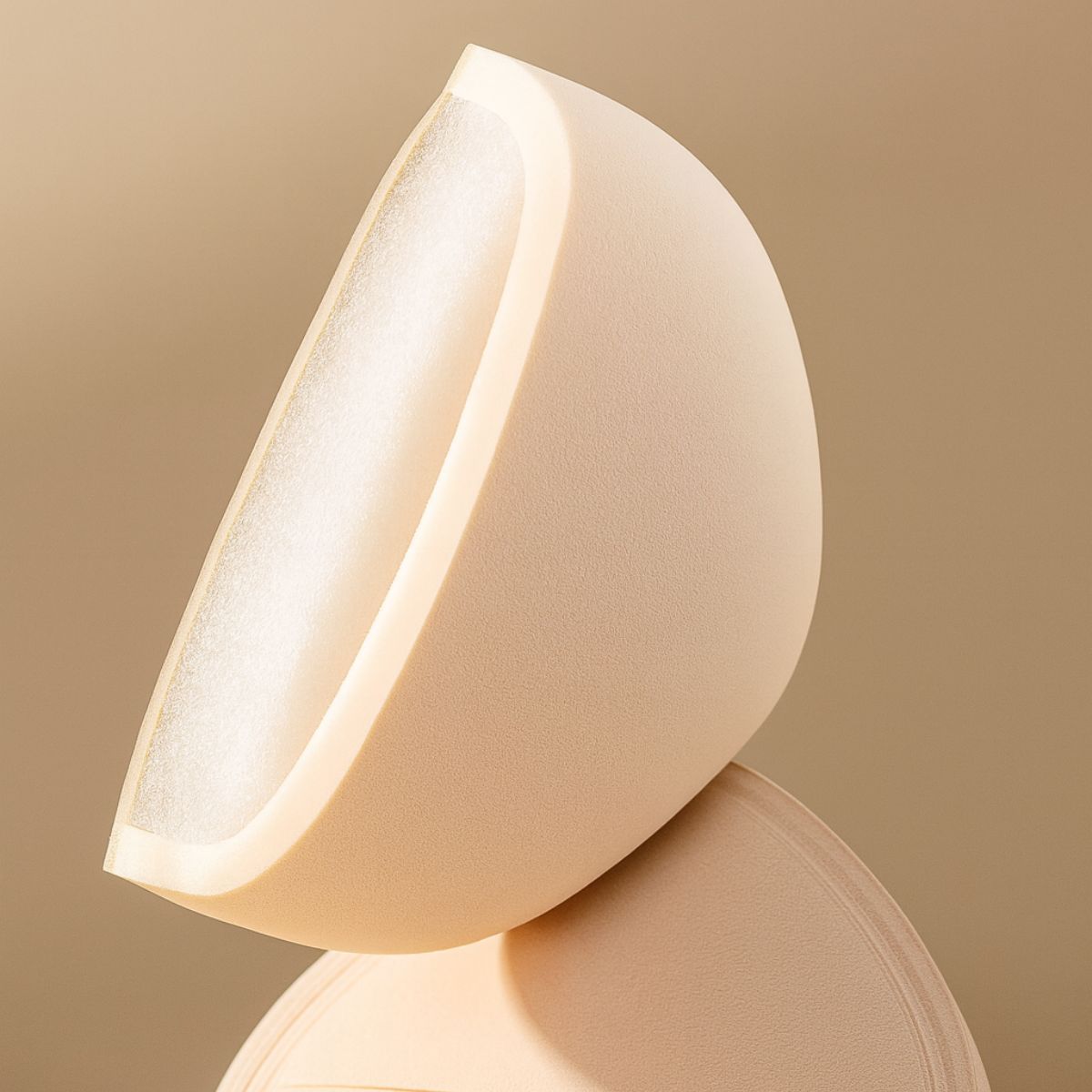 Forme hémisphérique en mousse couleur chair, à pores ouverts à l'intérieur.