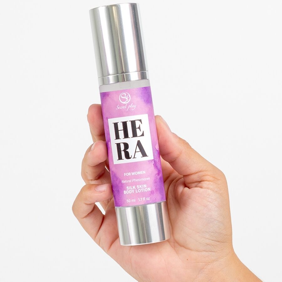 Flacon de lotion Hera, argenté. Inscription : "Hera", "For women", "Silk Skin Body Lotion". Main tenant le flacon.