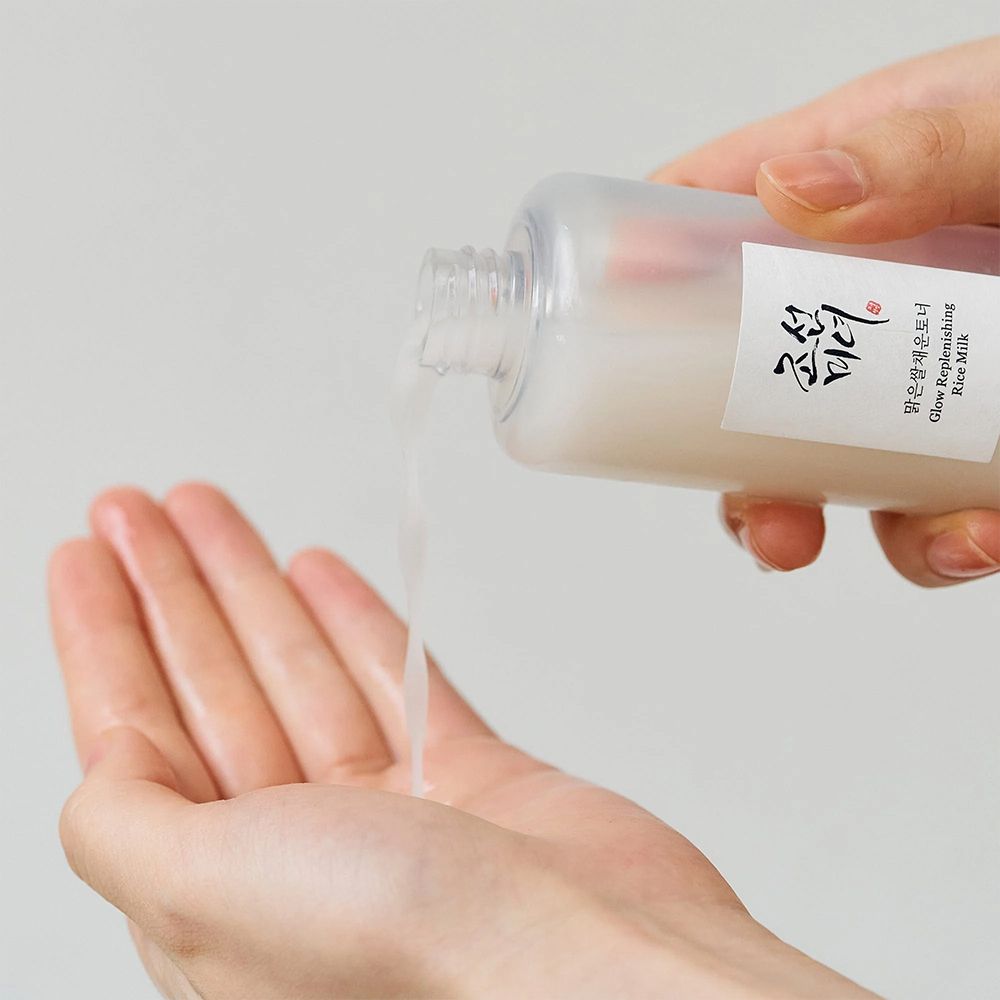 Vloeistof wordt uit een fles in een open handpalm gegoten.