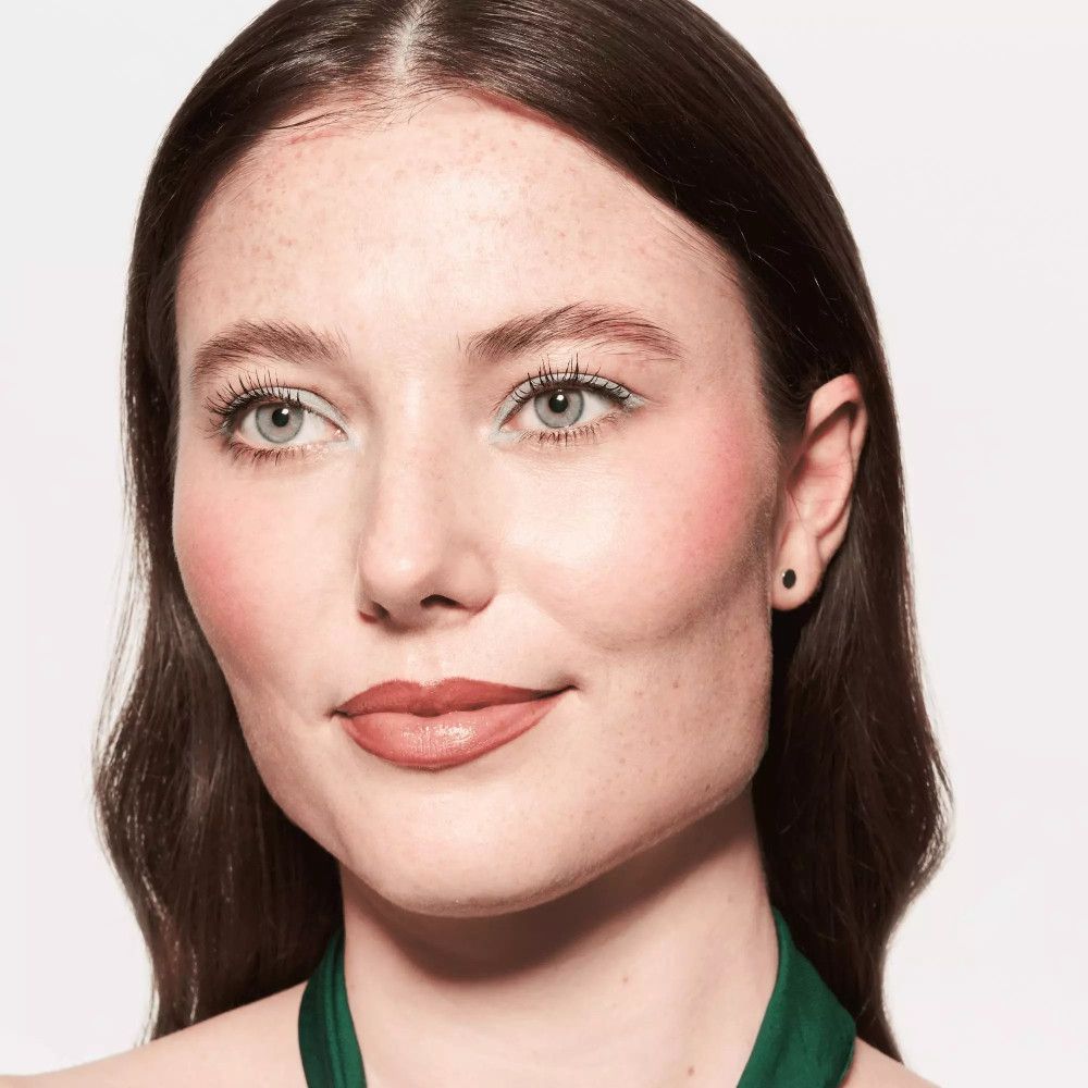 Portret van een vrouw met bruine lippenstift. Ze draagt een groene sjaal.