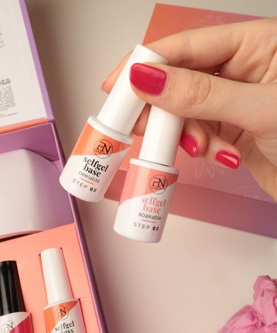 Deux flacons avec bouchon blanc. Inscription: selfgel base soakable, STEP 02. Logo PN. Tenus en main.