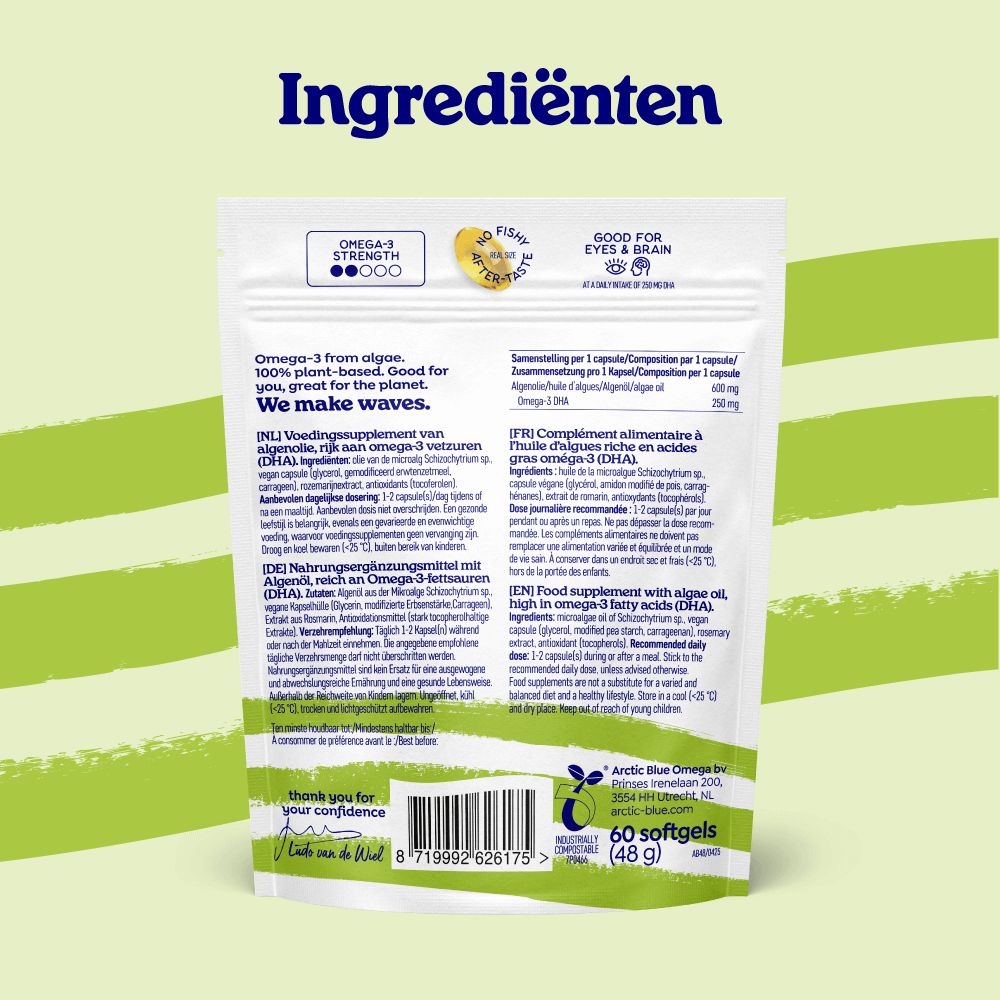 Een hand houdt een gele algenolie capsule boven een blauw glas water, met capsules ernaast.