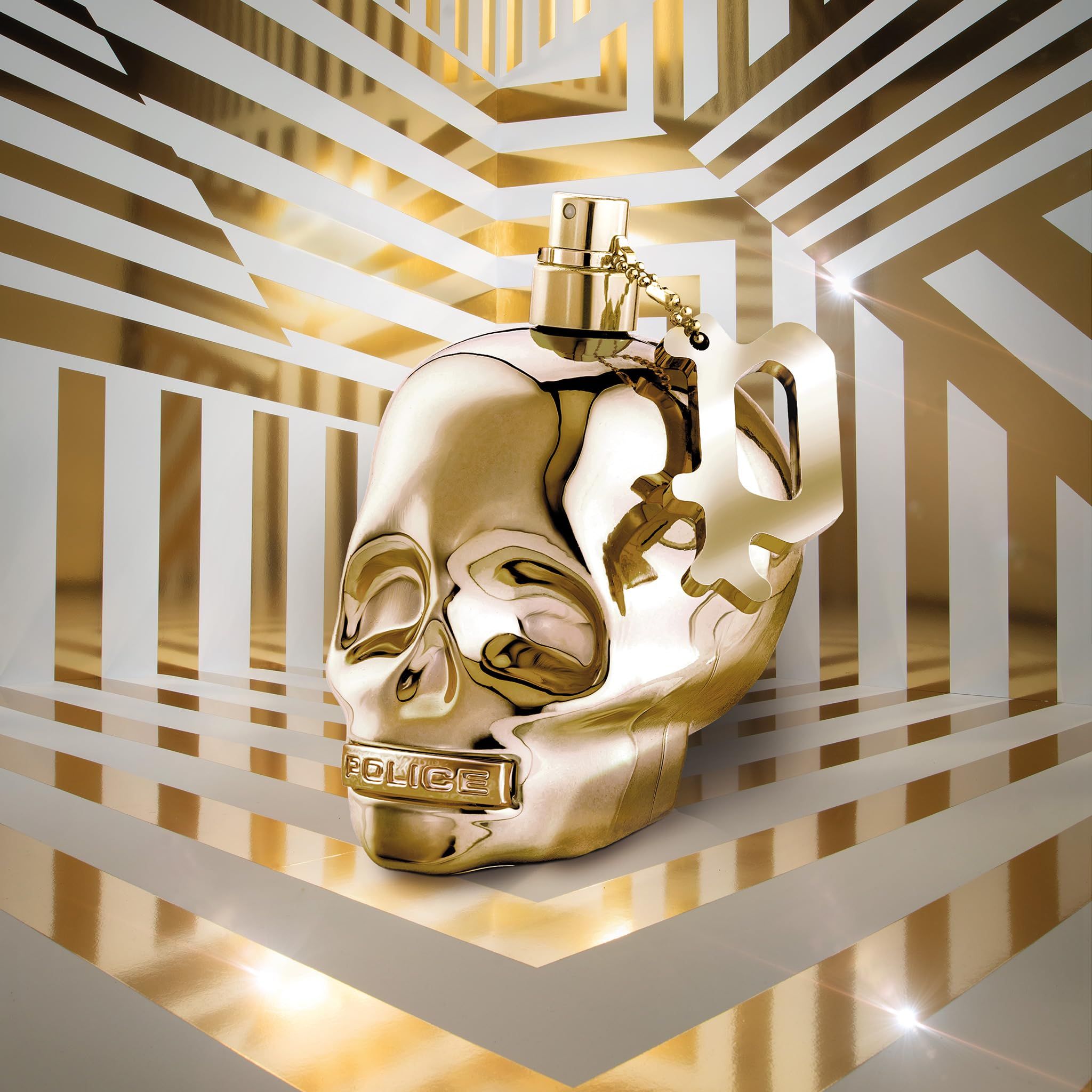 Flacon de parfum doré en forme de tête de mort avec pendentif, sur fond abstrait.